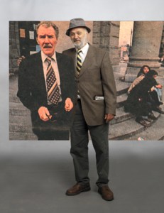 Playwright Bob Sarti poses with an image of the late Bruce Erikson